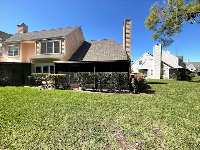 back of house featuring a lawn, central AC, a chimney, and a sunroom