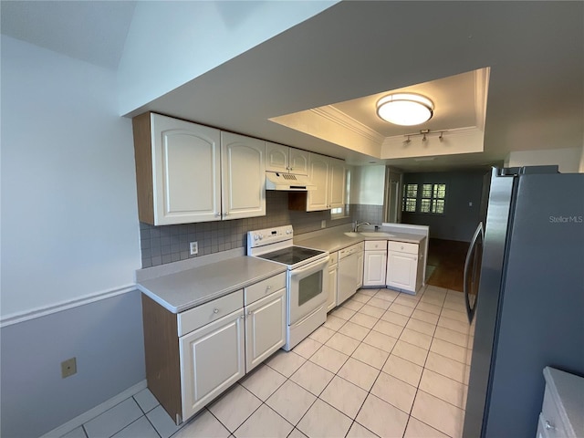 kitchen featuring white appliances, a tray ceiling, light tile patterned flooring, under cabinet range hood, and tasteful backsplash