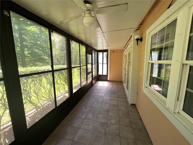 unfurnished sunroom with ceiling fan