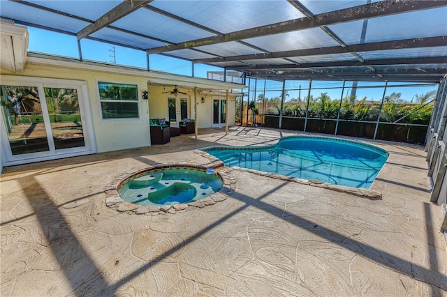 view of swimming pool with a pool with connected hot tub, glass enclosure, french doors, a patio area, and a ceiling fan