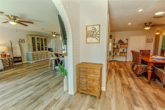 dining room featuring ceiling fan, wood finished floors, baseboards, and a textured ceiling