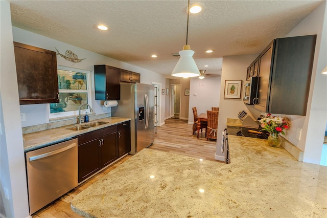 kitchen with recessed lighting, dark brown cabinets, stainless steel appliances, and a sink