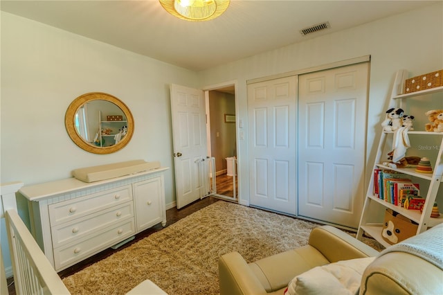 bedroom with a closet, visible vents, and baseboards