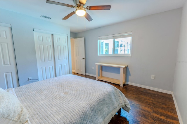 bedroom featuring visible vents, multiple closets, a ceiling fan, dark wood-style floors, and baseboards