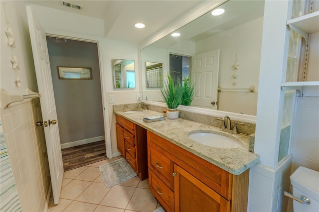 bathroom featuring tile patterned floors, double vanity, visible vents, and a sink