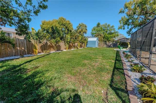 view of yard featuring a storage shed, an outbuilding, and a fenced backyard