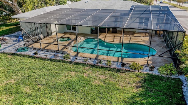 outdoor pool featuring glass enclosure, an in ground hot tub, a lawn, and a patio