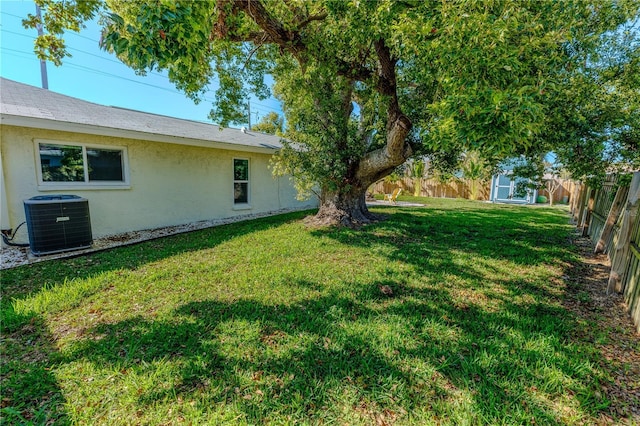 view of yard with cooling unit, a storage shed, a fenced backyard, and an outdoor structure