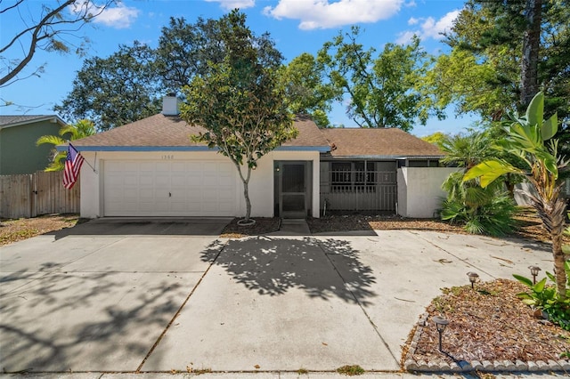 ranch-style house featuring fence, roof with shingles, driveway, stucco siding, and a garage