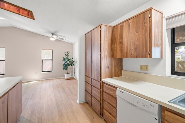 kitchen featuring dishwasher, light countertops, and lofted ceiling