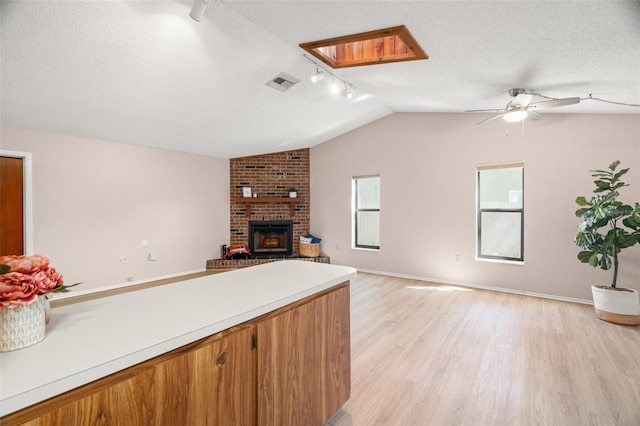 kitchen with visible vents, open floor plan, light countertops, light wood-style flooring, and a textured ceiling