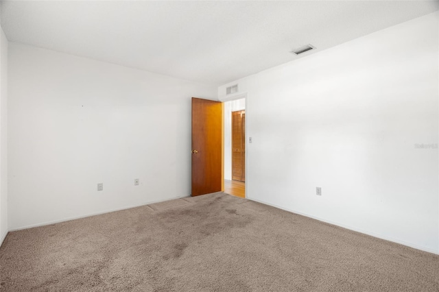 spare room featuring visible vents and carpet