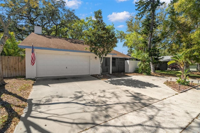 ranch-style home featuring stucco siding, fence, concrete driveway, a garage, and a chimney