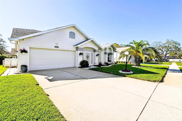 view of front facade featuring stucco siding, an attached garage, concrete driveway, and a front lawn