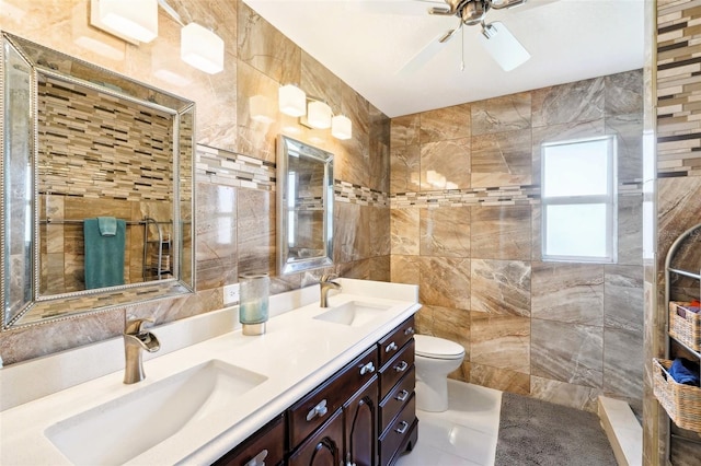 full bath with a tile shower, tile walls, a ceiling fan, and a sink