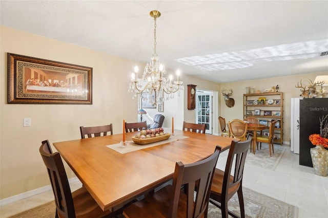 dining room featuring a notable chandelier, visible vents, and baseboards