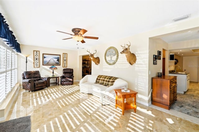 living room featuring visible vents, baseboards, and ceiling fan