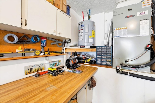 kitchen with water heater, white cabinetry, and a textured ceiling