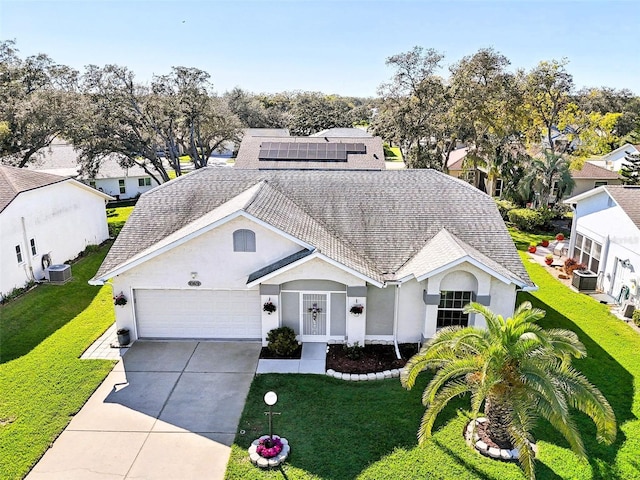 view of front of property with central air condition unit, a garage, driveway, and a front yard