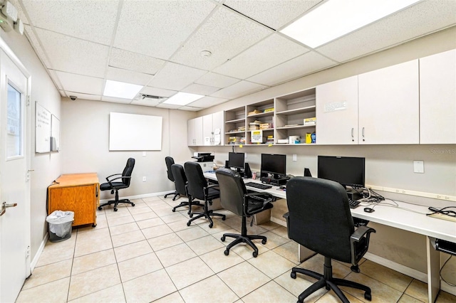 office space featuring light tile patterned floors, a drop ceiling, baseboards, and visible vents