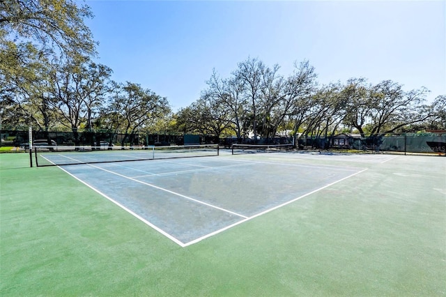 view of tennis court with community basketball court and fence