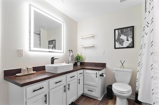 full bathroom with visible vents, toilet, wood finished floors, and vanity