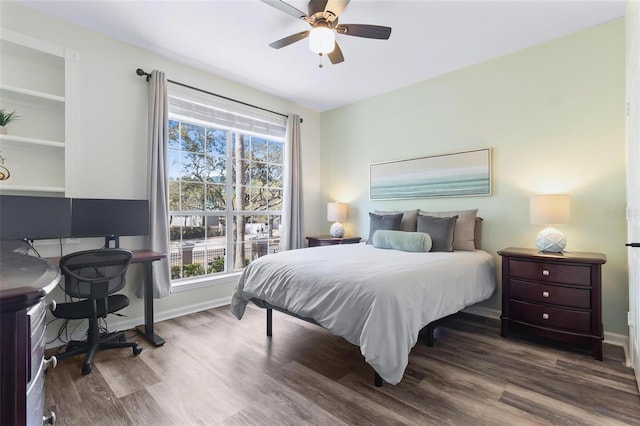 bedroom featuring baseboards, wood finished floors, and a ceiling fan