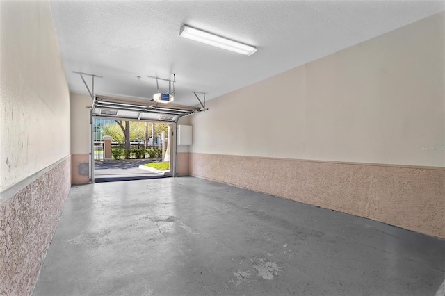 garage featuring a garage door opener and wainscoting