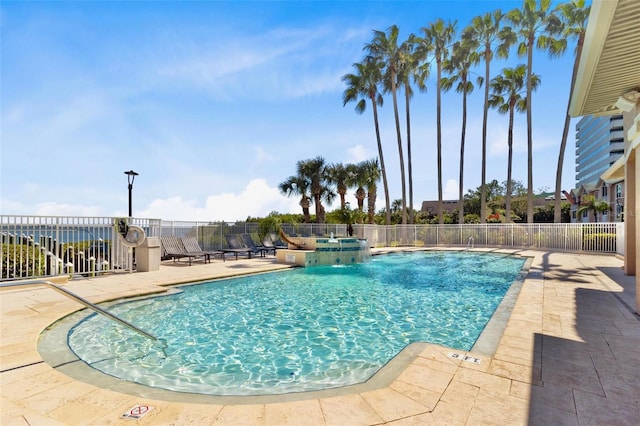 pool featuring a hot tub, a patio, and fence