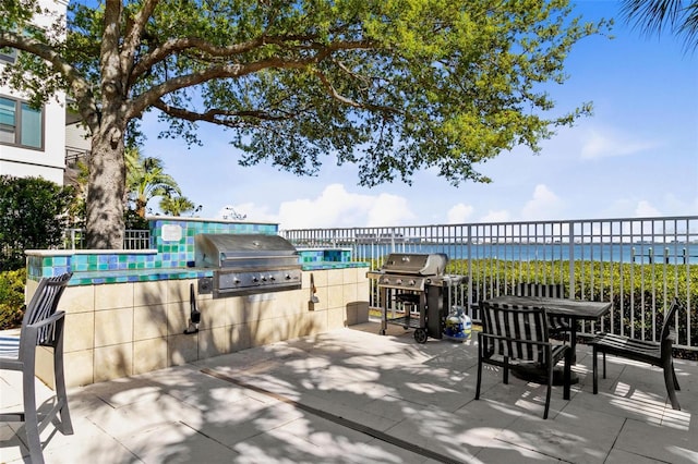 view of patio / terrace featuring area for grilling and a water view