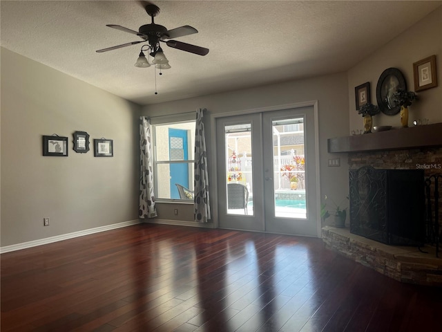 unfurnished living room with a wealth of natural light, french doors, a textured ceiling, and wood finished floors