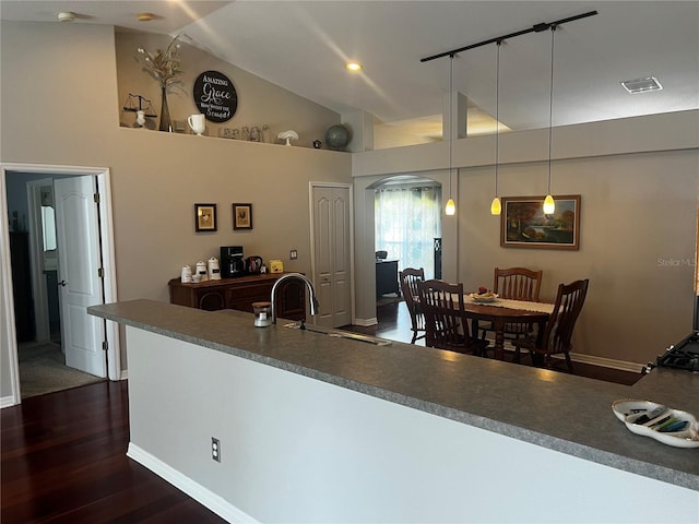 kitchen with visible vents, high vaulted ceiling, a sink, dark wood finished floors, and arched walkways