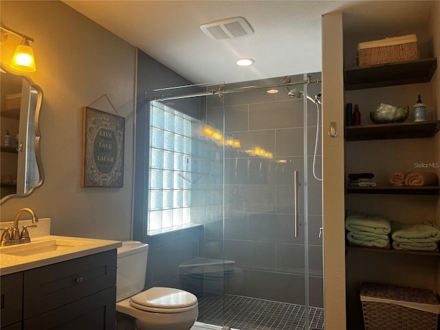 full bath with visible vents, vanity, toilet, and a shower stall