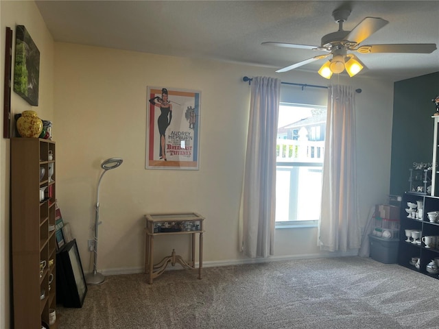 misc room with carpet, a healthy amount of sunlight, and a ceiling fan