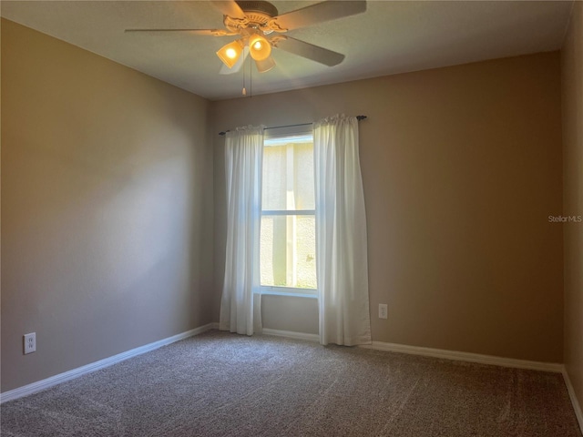 carpeted empty room with baseboards and a ceiling fan