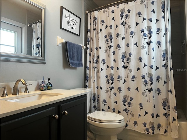 bathroom with vanity, shower / bath combination with curtain, and toilet