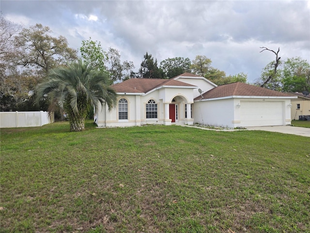 mediterranean / spanish house featuring stucco siding, concrete driveway, a front lawn, and fence