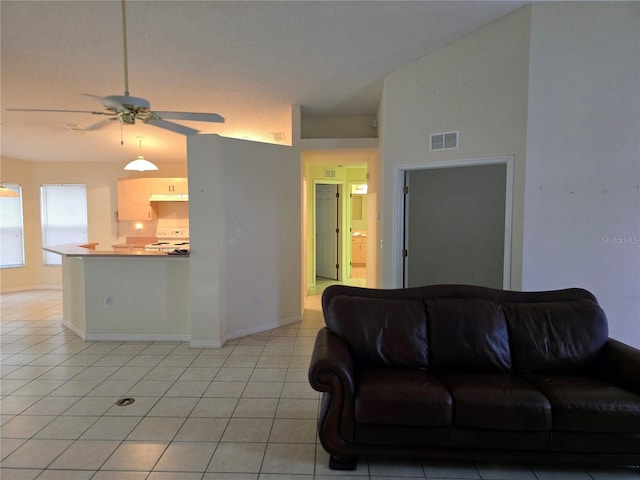 living area featuring visible vents, a ceiling fan, light tile patterned floors, baseboards, and vaulted ceiling