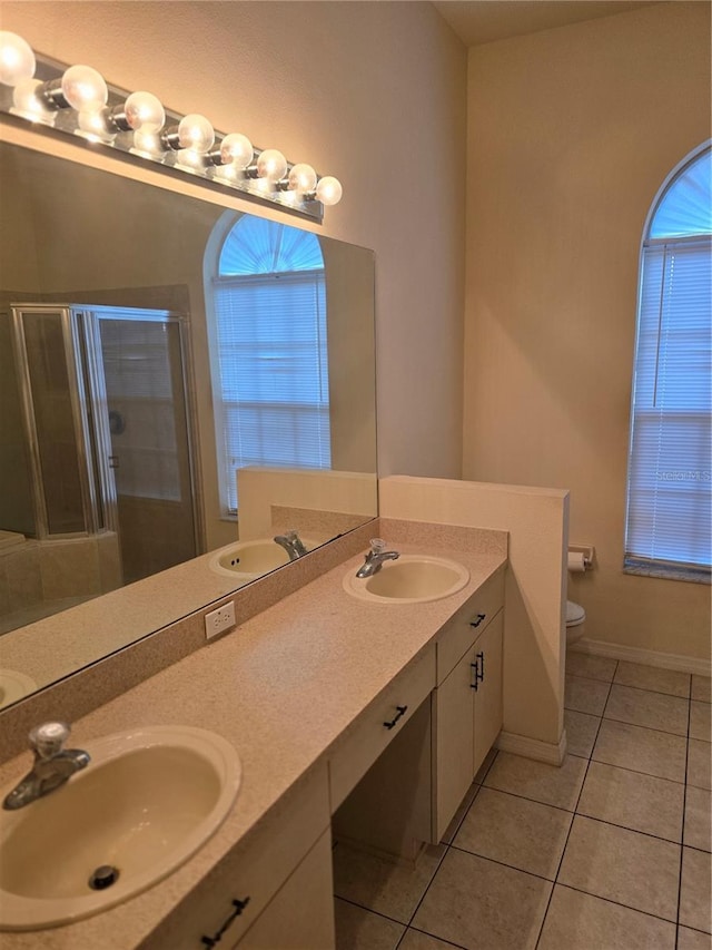 full bath with a shower stall, toilet, tile patterned floors, and a sink