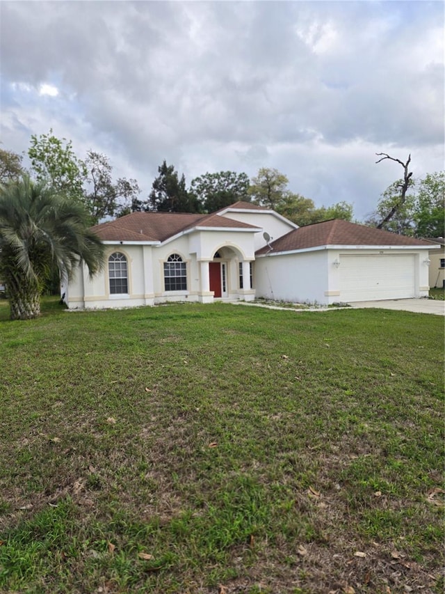 view of front of property featuring a front lawn, a garage, and stucco siding