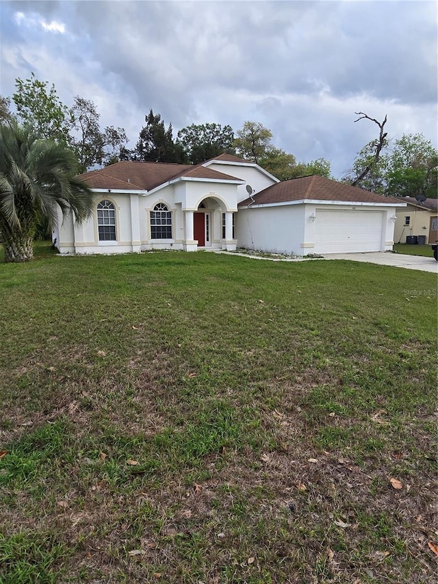 view of front facade featuring a front yard, driveway, and stucco siding