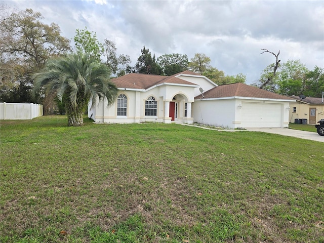 mediterranean / spanish house featuring stucco siding, concrete driveway, a front lawn, and fence