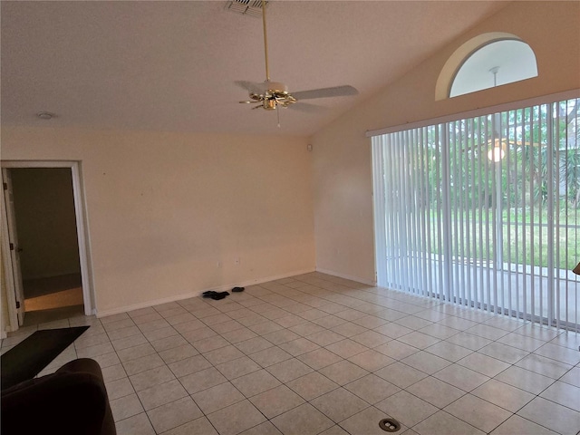 empty room featuring light tile patterned floors, visible vents, a ceiling fan, and lofted ceiling