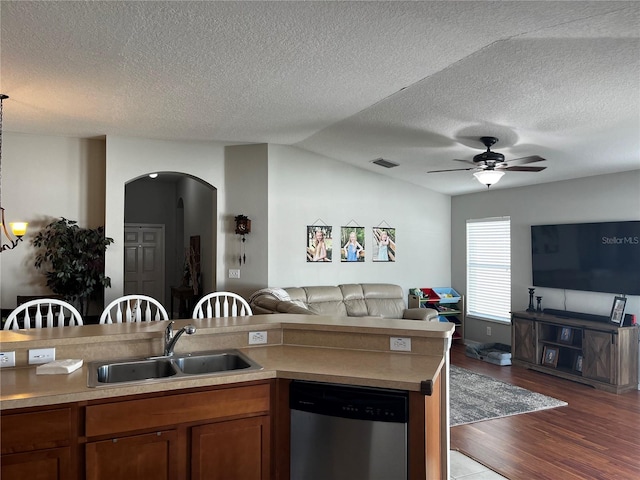 kitchen with a sink, stainless steel dishwasher, open floor plan, brown cabinetry, and dark wood-style flooring