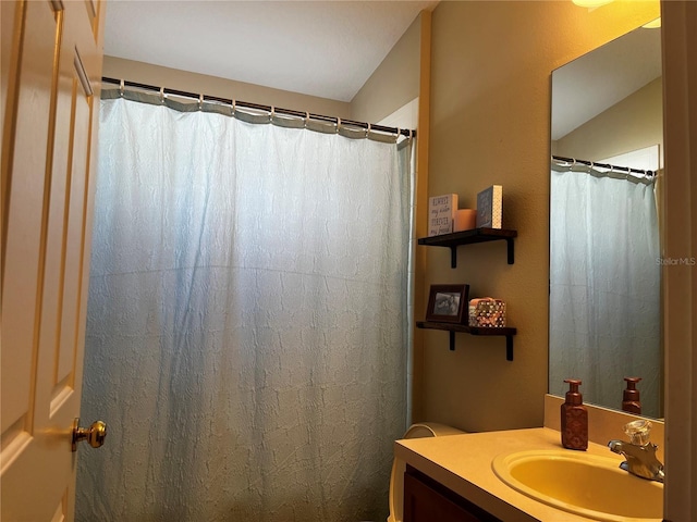 full bath featuring vanity and lofted ceiling