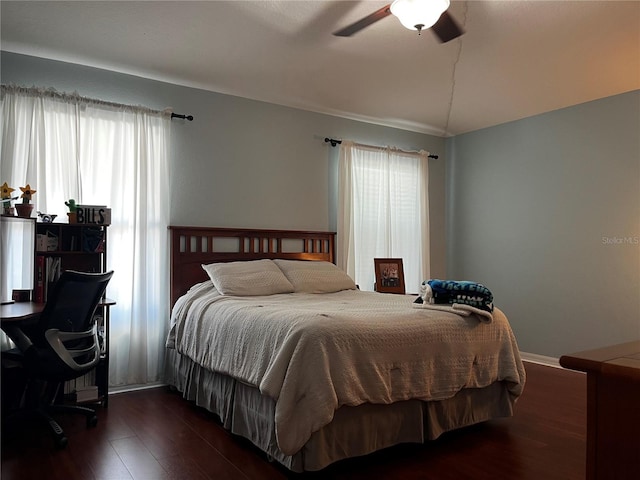 bedroom featuring baseboards, dark wood-type flooring, and a ceiling fan