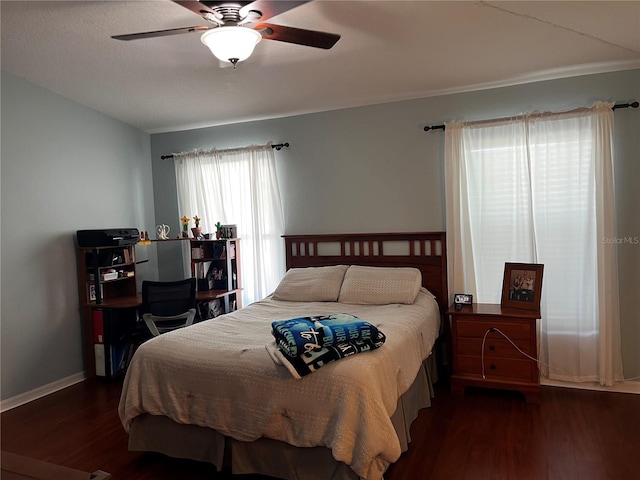 bedroom with ceiling fan, baseboards, and wood finished floors