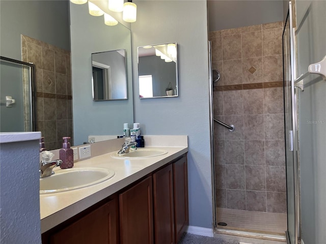 full bath with double vanity, a stall shower, and a sink