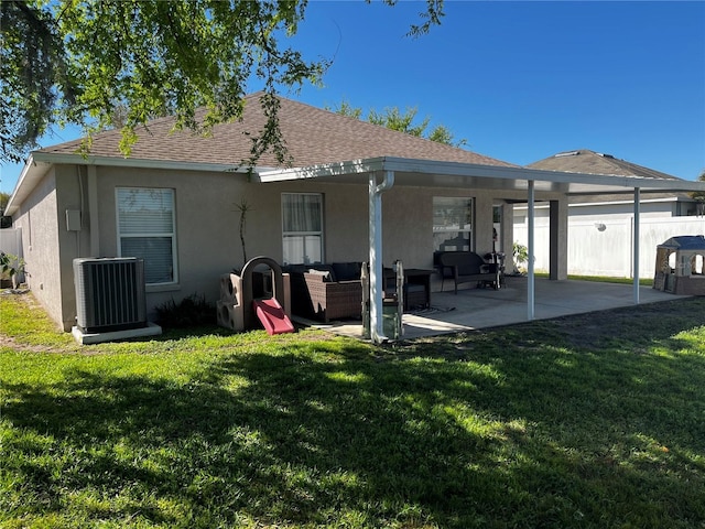 back of house featuring outdoor lounge area, a patio, fence, and a lawn