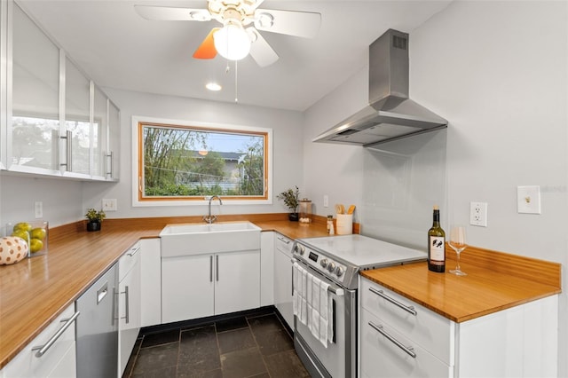 kitchen with a sink, stainless steel electric stove, white cabinets, island range hood, and ceiling fan